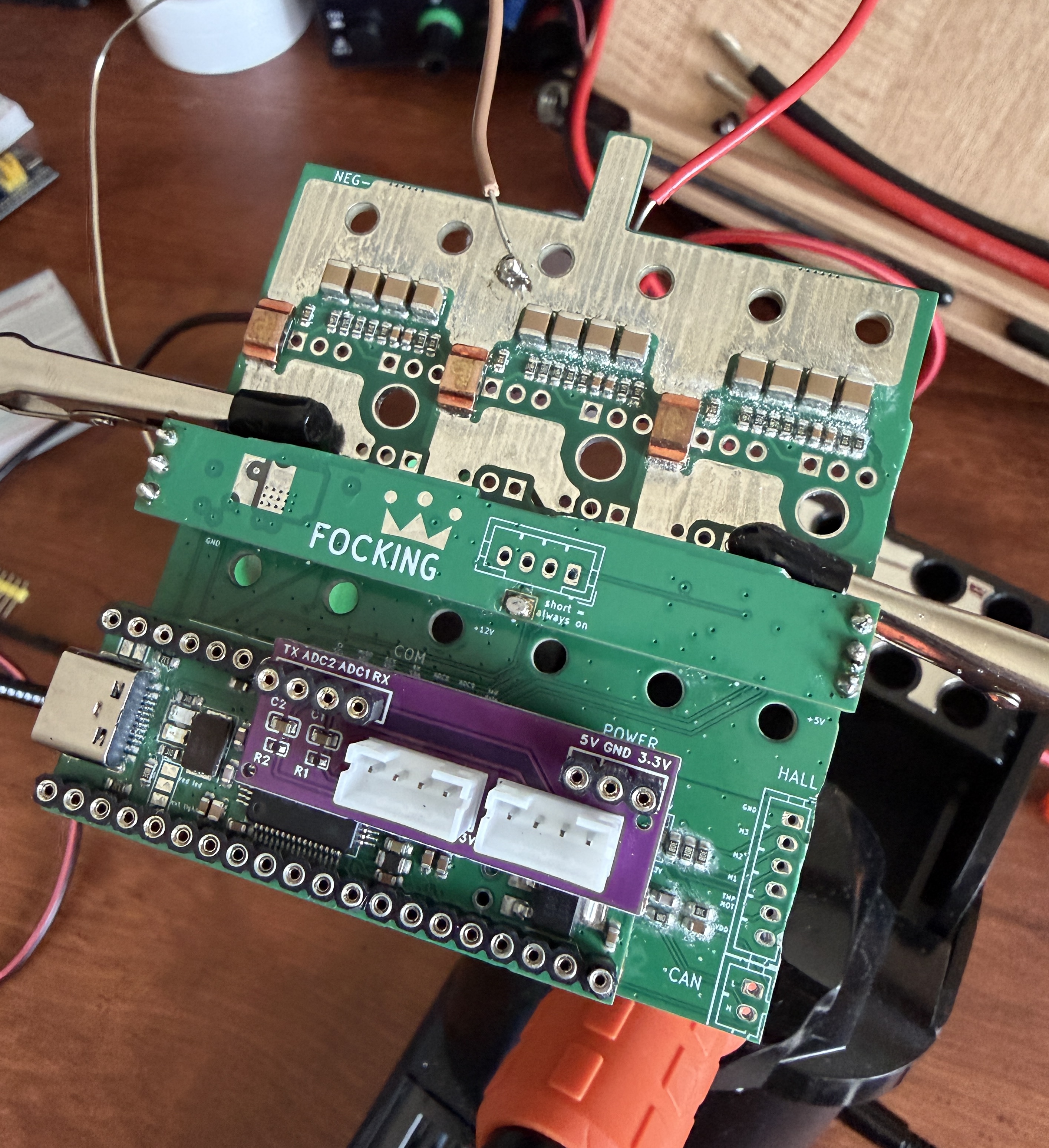 The purple expansion board plugged into the FOCKING controller's header, next to the STM32 module, on the bench