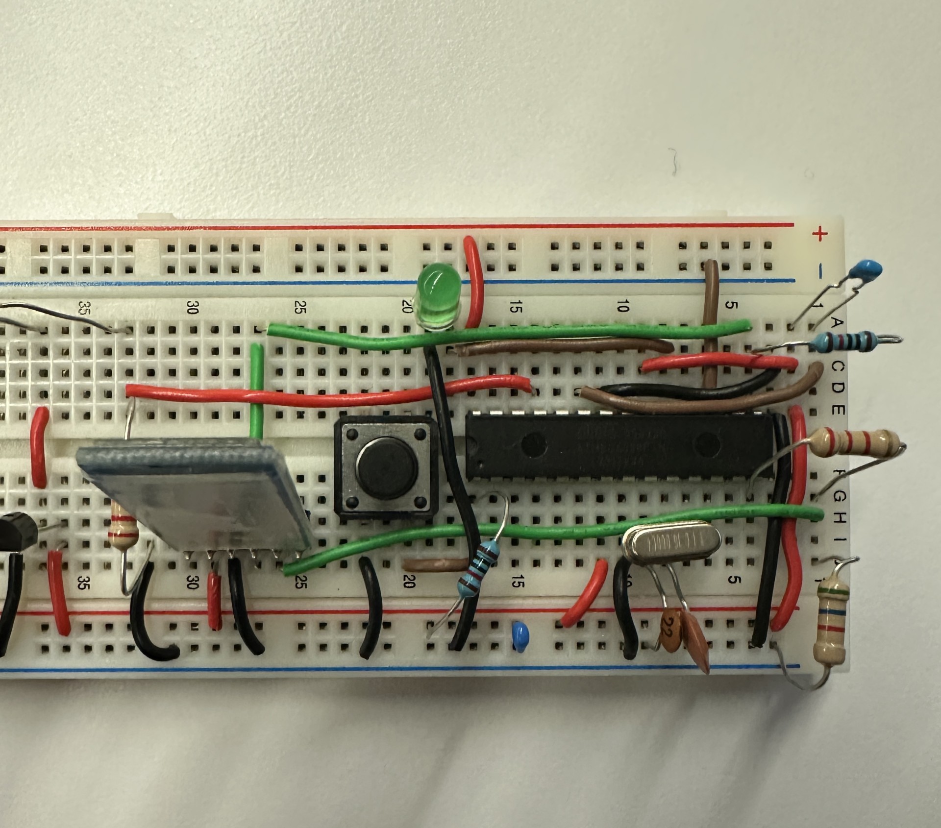 The microcontroller half of the breadboard: an ATmega328P in a DIP package, a Bluetooth module, crystal oscillator, reset button, status LED, and divider resistors